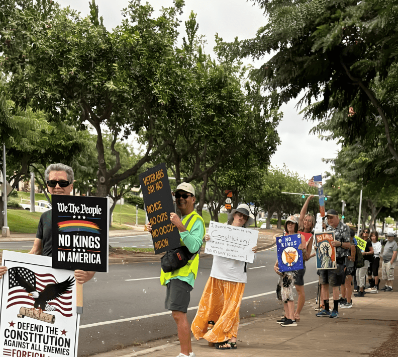 Demonstrators holding various protest signs.