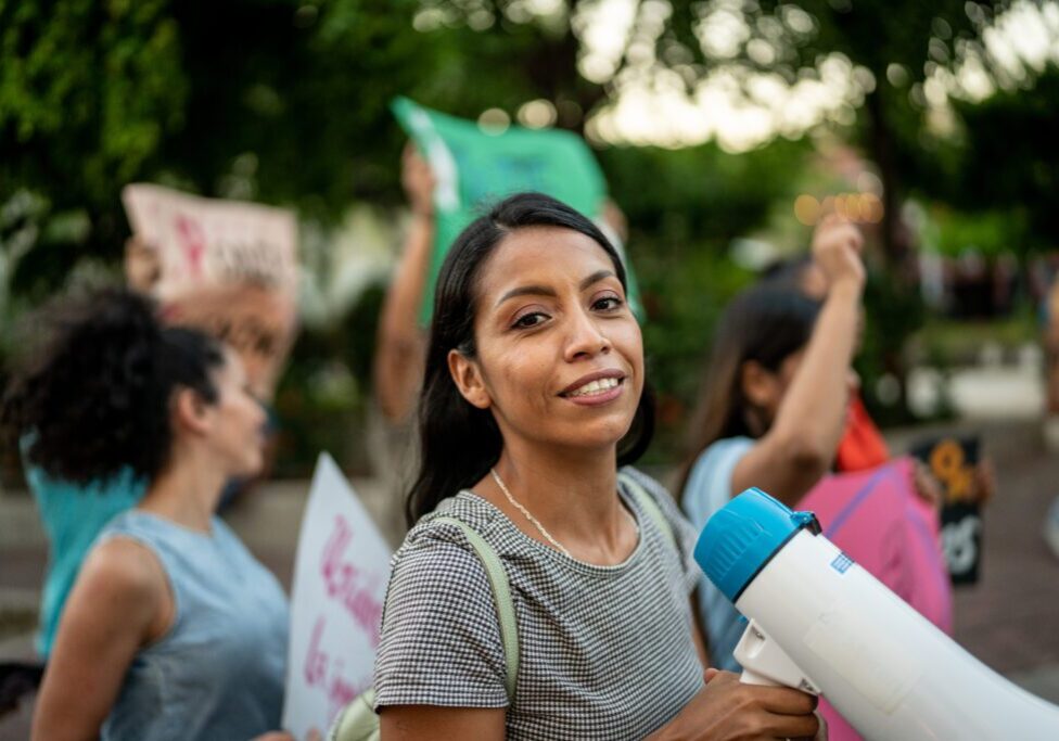Smiling protester with megaphone outdoors
